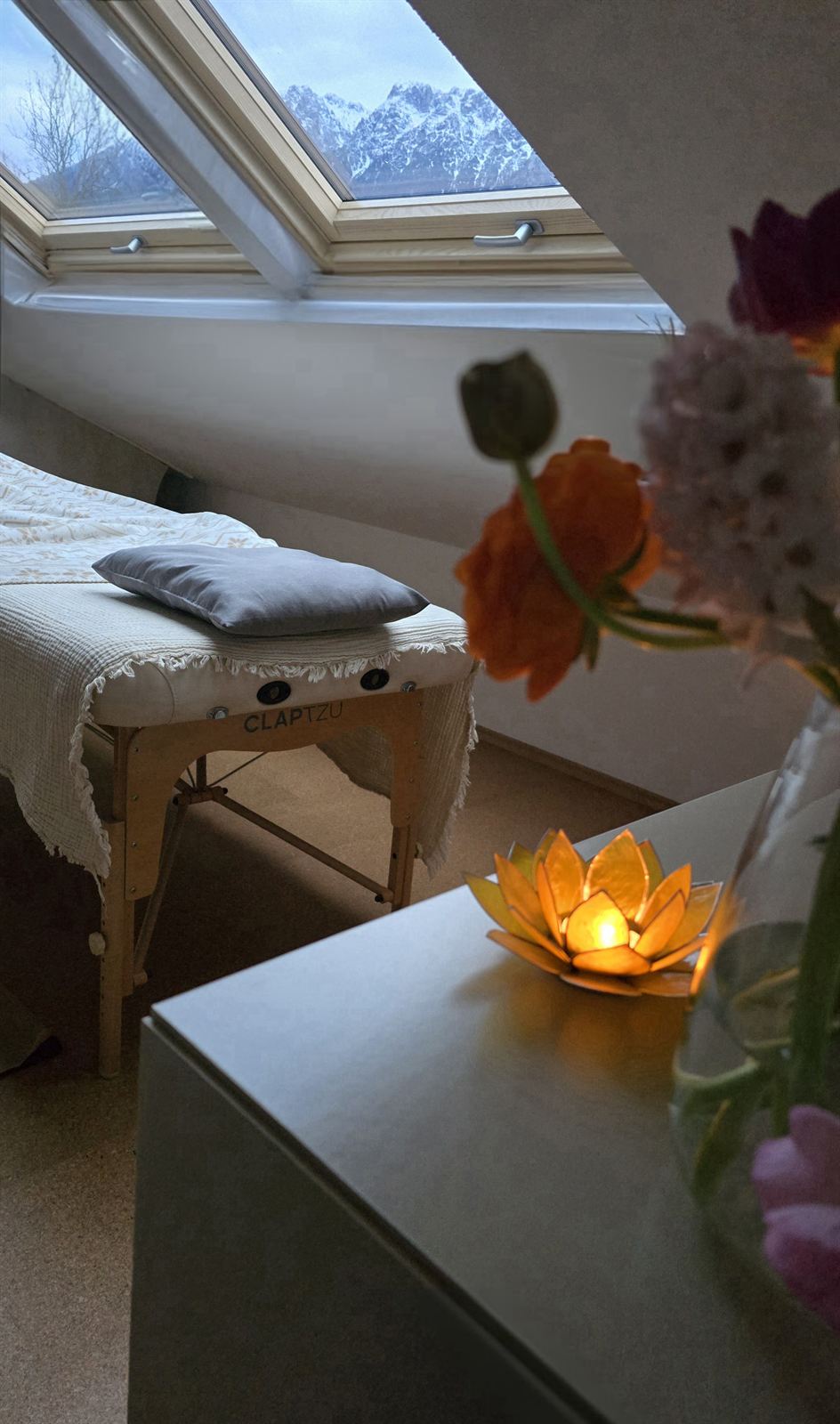 Behandlungsliege im Studio mit Blick auf die Berge, Blumen und Lotuslampe